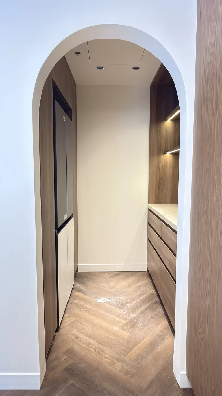 Arched walk-in pantry in Dubai with bespoke joinery and LED shelving