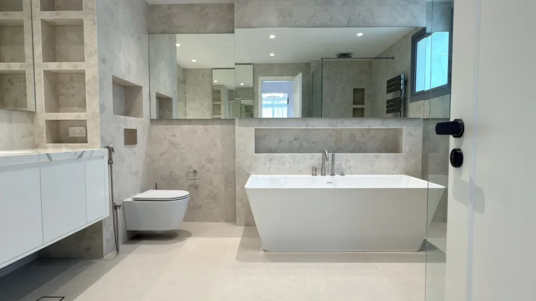 Bathroom fit-out in Dubai with freestanding bath, stone cladding and fitted vanity