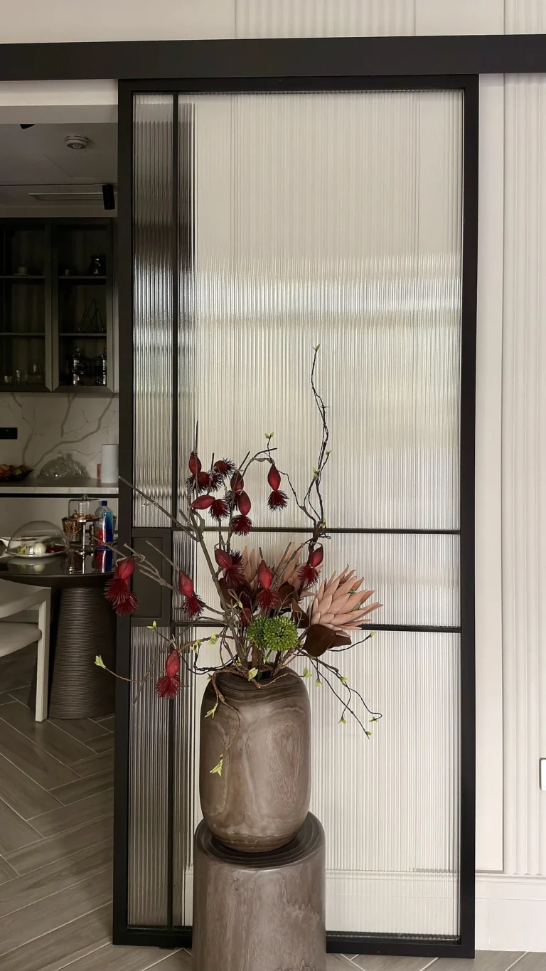 Fluted glass sliding partition in Dubai with slim black metal framing