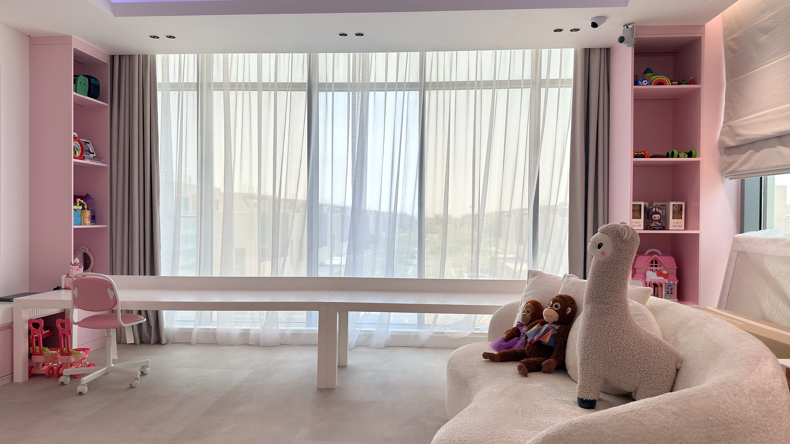 Kids bedroom fit-out in Dubai with pink shelving and built-in study desk