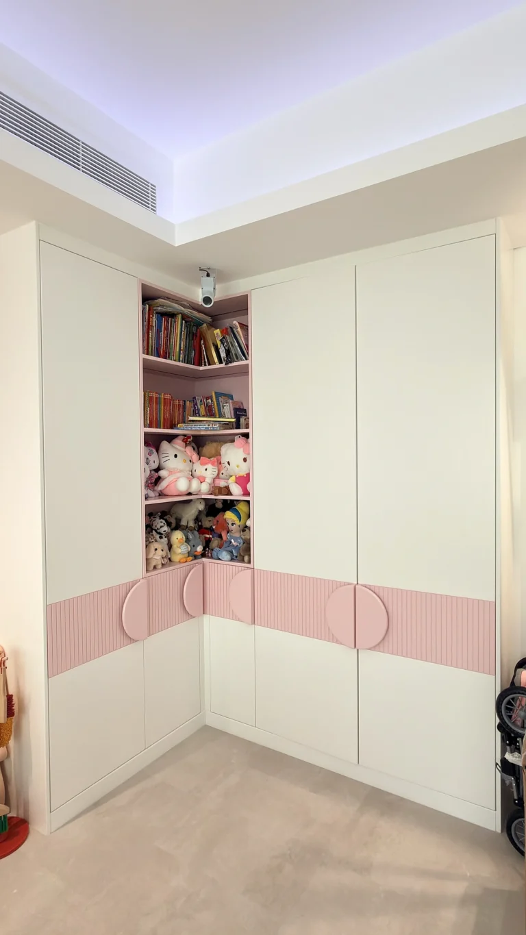 Kids bedroom wardrobe in Dubai with white doors, pink detailing and open bookshelf
