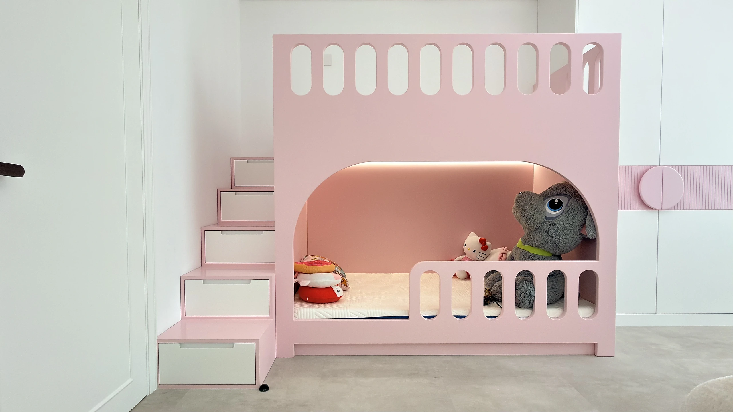 Bespoke pink bunk bed with staircase and play-house frontage in a Dubai kids bedroom