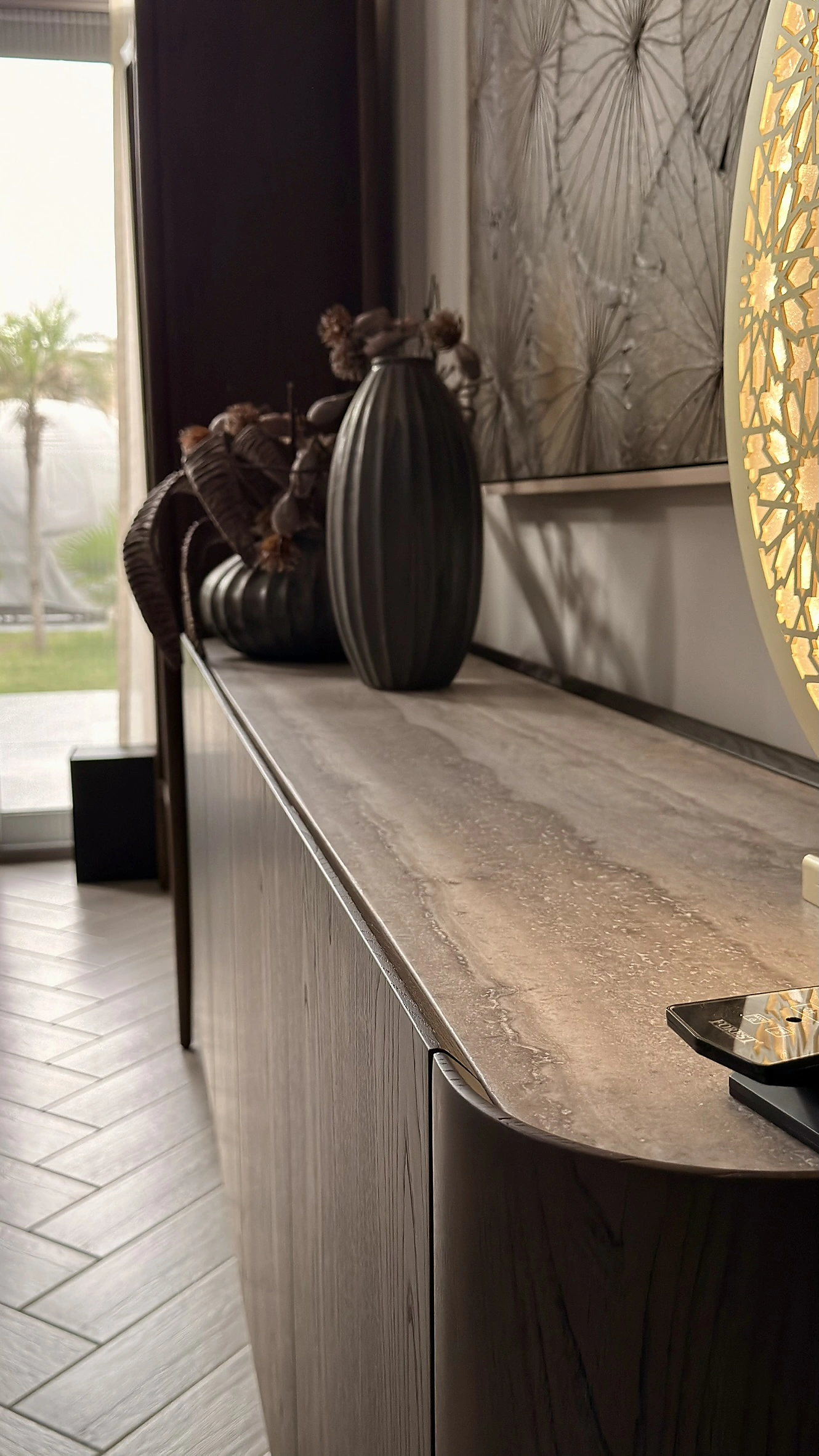 Curved entrance console in Dubai with a travertine top and grey oak body below a backlit mirror