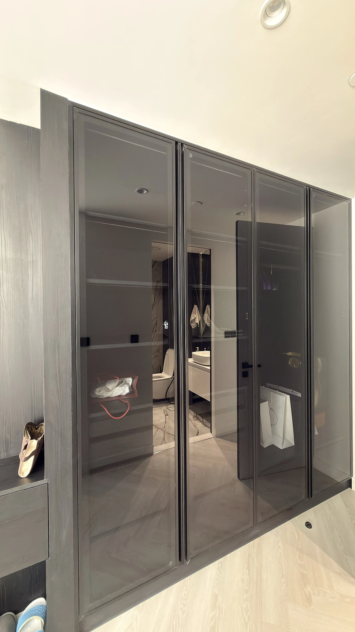 Walk-in wardrobe with grey glass doors and aluminium frame, Dubai